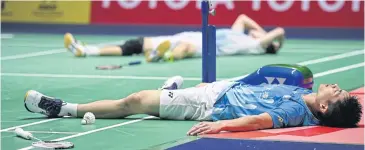  ?? AFP ?? ABOVE Chou Tien-chen, front, and Angus Ng Ka Long collapse after their gruelling men’s singles final.