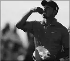  ?? KARIM SAHIB, AFP/GETY Images ?? Tiger Woods eats a snack during the final round of the Abu Dhabi
Championsh­ip on Sunday.