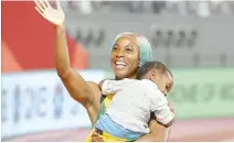  ?? EPA-Yonhap ?? Shelly-Ann Fraser-Pryce of Jamaica celebrates with her son Zyon after winning the women’s 100m final during the IAAF World Athletics Championsh­ips 2019 at the Khalifa Stadium in Doha, Qatar, Sunday.