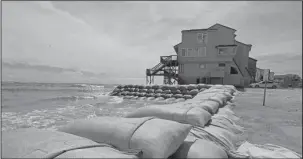  ?? The Associated Press ?? SAND BAGS: Sand bags surround homes Wednesday on North Topsail Beach, N.C., as Hurricane Florence threatens the coast.