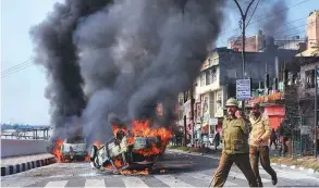  ?? PTI ?? Policemen patrol a street in Jammu yesterday after vehicles were set on fire by protesters against the killing of CRPF personnel in the Kashmir attack.