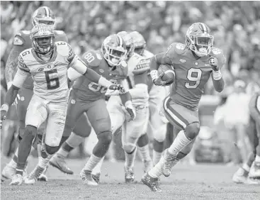  ?? Rainier Ehrhardt / Associated Press ?? Clemson running back Travis Etienne, right, ran for 97 yards and a pair of touchdowns as the fourth-ranked Tigers nailed down the Atlantic Coast Conference Atlantic Division title with a 31-14 win over Florida State.