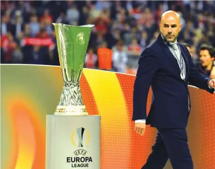  ??  ?? Ajax coach Peter Bosz walks past the trophy Photo: AP