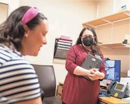  ?? PHOTOS BY NATHAN KLIMA/USA TODAY ?? Dr. Rebecca Mishuris, right, an internist at Brigham and Women's Hospital, has been piloting competing software applicatio­ns that use large-language models and generative AI to assist her during interactio­ns with patients.