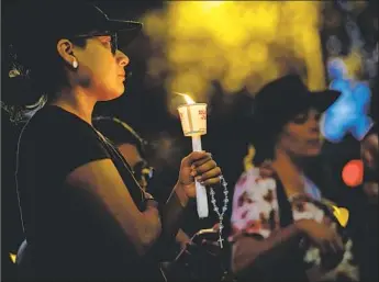  ?? Marcus Yam Los Angeles Times ?? MEMBERS of the community pay their respects Sunday night to Melyda Corado, a store manager who was killed in Saturday’s shootout involving a gunman and LAPD officers at Trader Joe’s in Silver Lake.