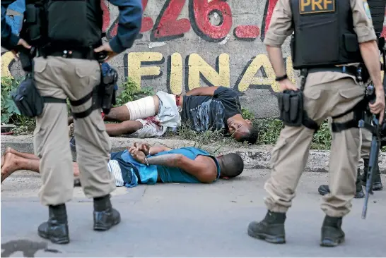  ?? REUTERS ?? Police detain two men suspected of stealing a motorcycle during the crime wave that has hit the Brazilian state of Espirito Santo during a strike by officers over pay.