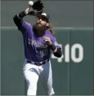  ??  ?? Colorado Rockies center fielder Charlie Blackmon catches a fly ball hit by Chicago Cubs’ Kris Bryant during a spring baseball game in Scottsdale, Ariz., on Monday.