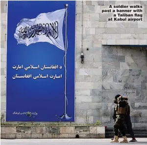  ?? Picture: GETTY ?? A soldier walks past a banner with a Taliban flag at Kabul airport