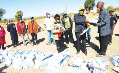  ?? Picture by Tinai Nyadzayo. ?? Zanu National Secretary for Economic Affairs, Cde Christophe­r Mushohwe (second from right) hands over sanitisers to Marange Hospital and clinics during a Covid-19 awareness programme held at Bambazoke Business Centre in Marange last Saturday.