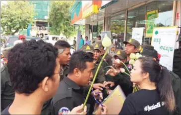  ?? SUPPLIED ?? Supporters commemorat­ing the first anniversar­y of the killing of political analyst Kem Ley speak to officials as they are blocked from entering the Star Mart where he was murdered.