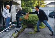  ?? JOSE CARLOS FAJARDO — STAFF PHOTOGRAPH­ER ?? Jason Alderman of Piedmont stretches to give a bag of avocados to Carolyn Horgan and her husband, Jonathan Crowl, of Piedmont during a grocery store home delivery on April 2.