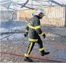  ?? Foto: Reuters / Pascal Rossigno ?? Feuerwehr am Tag danach im ausgebrann­ten Flüchtling­slager.
