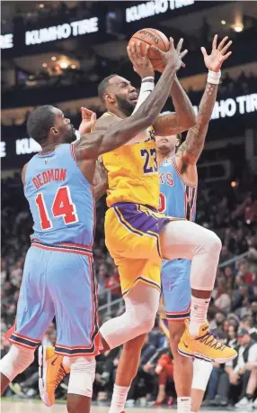  ??  ?? Lakers forward Lebron James goes to the basket against Hawks center Dewayne Dedmon on Tuesday in Atlanta. The Hawks won 117-113. JOHN BAZEMORE/AP