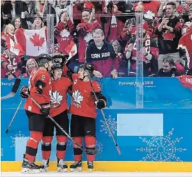  ?? NATHAN DENETTE THE CANADIAN PRESS ?? Canada forward Christian Thomas (92) celebrates his goal with teammates Chay Genoway (5) and Wojciech Wolski (8) during the first period of Sunday’s game against South Korea.
