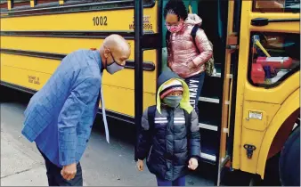  ?? Peter Hvizdak / Hearst Connecticu­t Media ?? Keith Young welcomes students as they arrive at Lincoln Bassett Community School in New Haven on Jan. 19. Connecticu­t schools are to receive $1.2 billion in aid under a federal pandemic relief bill that was endorsed on Saturday by the Senate.