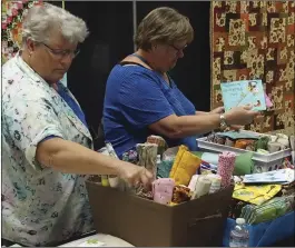  ??  ?? Doreen Herregodts (left) and Luise Norman, quilters from Canada wintering at the Fountain of Youth Spa, rummage through fabric scraps Sunday at the Desert Quilters of Imperial Valley Quilt Show. PHOTO TOM BODUS