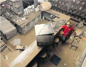  ?? STUART GRADON/FILES ?? Owner Dominic Caracciolo explores the flooded lower floor of Wurst restaurant in Calgary in 2013.