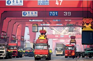  ??  ?? Manutentio­n des conteneurs d’un navire étranger, dans le port de Qingdao