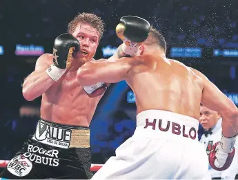  ??  ?? GOLPE. Gennady Golovkin recibe el puñetazo del mexicano Canelo álvarez.