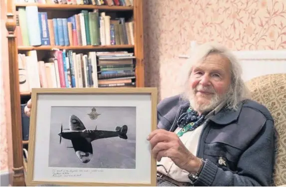  ?? Ministry of Defence ?? Dr Edmund James with a replacemen­t Spitfire picture, after his original was stolen from his home