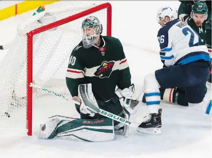  ?? PHOTOS: JIM MONE/THE ASSOCIATED PRESS ?? Winnipeg Jets captain Blake Wheeler was in Devan Dubnyk’s face as Mark Scheifele put the puck past the Minnesota Wild goaltender on Tuesday night. The Jets won Game 4 of the first-round series 2-0 in St. Paul, Minn., to take a 3-1 series lead.