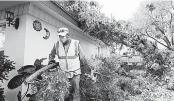  ?? ERIC GAY/AP ?? Hanna’s aftermath: Juan Martinez helps clear debris left by the hurricane Monday in Weslaco,Texas. Initial reports indicated Hanna dumped up to 15 inches of rain in some areas of South Texas. A downgraded Hanna still threatened to bring rainfall and flash flooding Monday to parts of South Texas and Northern Mexico. Hanna slammed ashore Saturday.