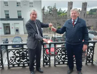  ??  ?? Smooth transition: Outgoing chairman of Macroom Muncipal District Council, Michael Looney, hands over his chain of office to his successor, Martin Coughlan, at the TownT Hall on Monday.
