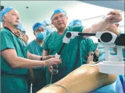  ?? ZHANG TAO / FOR CHINA DAILY ?? A doctor demonstrat­es how a robot conducts an orthopedic operation in Zhengzhou, Henan province.