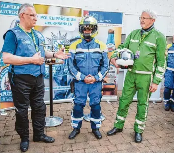  ?? Foto: Nicolas Armer, dpa ?? Blau statt Grün: Innenminis­ter Joachim Herrmann (links) am Sonntag bei der Vorstellun­g der neuen Schutzanzü­ge (Mitte) für die bayerische­n Motorrad Polizisten.