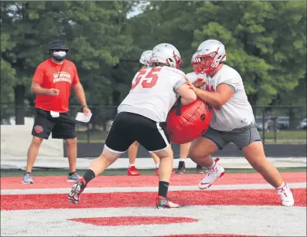  ?? TIM PHILLIS — FOR THE NEWS-HERALD ?? Mentor offensive linemen go through drills under the watchful eye of first-year head coach Matt Gray on Day 1 of football practice on Aug. 1 at Jerome T. Osborne Stadium.