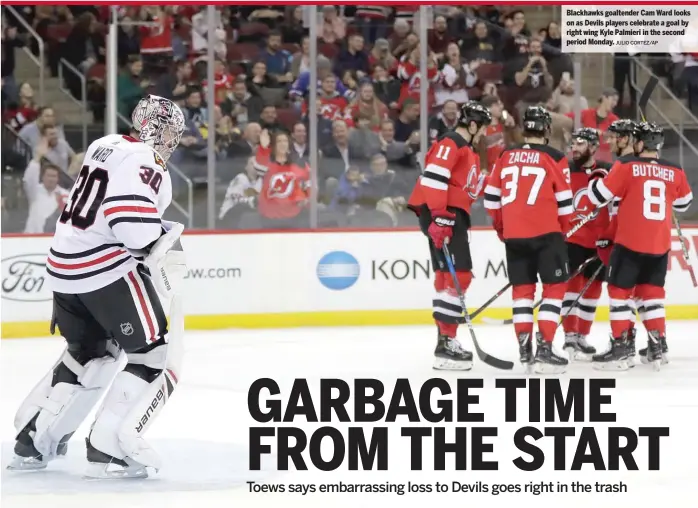  ?? JULIO CORTEZ/AP ?? Blackhawks goaltender Cam Ward looks on as Devils players celebrate a goal by right wing Kyle Palmieri in the second period Monday.