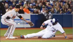  ?? The Canadian Press ?? Toronto Blue Jay Kendrys Morales slides safely into third base as Baltimore Orioles third baseman Manny Machado tries to make a play during fourth inning AL baseball action in Toronto on Wednesday. The Orioles won 2-1.
