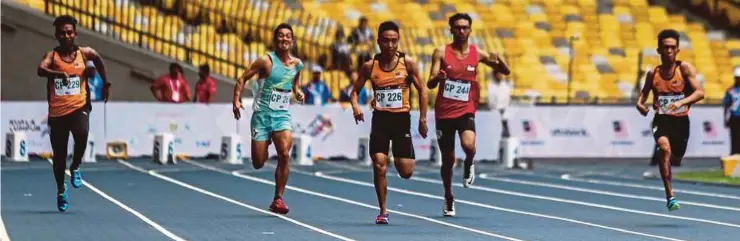  ?? PIC BY OSMAN ADNAN ?? Eddy Bernard (centre) crosses the line first for the 100m T37 title yesterday.