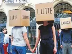  ?? AP ?? Students wearing boxes reading ‘Elite, Students, Struggle, Politics,’ perform in front of a blocked entry at the Institute of Political Studies or Sciences Po in Paris, France, yesterday.