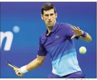  ?? Sarah Stier / Getty Images ?? Novak Djokovic returns the ball against Holger Vitus Nodskov Rune during the first round at the U.S. Open on Tuesday.