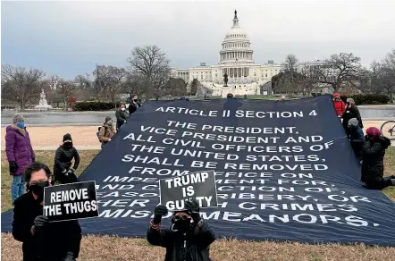  ?? AP ?? A group holds a banner urging that United States President Donald Trump be removed from office, near the US Capitol, in response to this week’s attack on the building by Trump supporters.