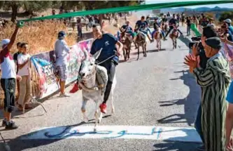  ??  ?? Moroccan men ride their donkeys during a race at the festival “Festibaz” in the village of Beni Ammar.