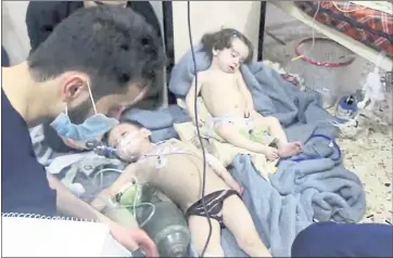  ?? SYRIAN CIVIL DEFENSE WHITE HELMETS VIA AP ?? Medical workers treat toddlers after an alleged poison gas attack in Douma, Syria, in this image made from video released by the Syrian Civil Defense White Helmets and authentica­ted based on its contents and AP reporting.