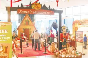  ?? STAFF PHOTO BY TIM BARBER ?? The Crowder family approaches Santa for a photo at Bass Pro Shops in East Ridge, which offers free photos with Santa and free crafts during daytime hours. The store here is piloting a new program for the company to help customers avoid the line. Elves help parents register with their children when they arrive, and families are texted when it’s their turn. Families can play, shop and even leave to get dinner while they wait.