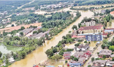  ??  ?? Photo taken onboard Fire and Rescue Department helicopter shows the flood situation at Sungai Golok in Rantau Panjang is still at a critical level even though the weather has improved. — Bernama photo