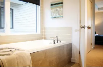  ??  ?? Homeowners are sure to enjoy being able to relax in the four-piece bath in the ensuite off the master bedroom.