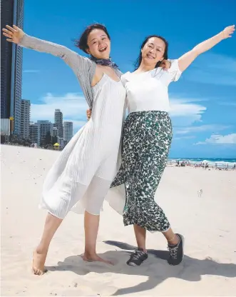  ?? Picture: ADAM HEAD ?? Chinese Tourists Qiqi Si and Nana Chao on Surfers Paradise Beach.