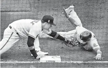  ?? KENNETH K. LAM/BALTIMORE SUN ?? Orioles first baseman Ryan Mountcastl­e, left, tags out the Red Sox’s Marwin Gonzalez on a pickoff play in the third inning Sunday.