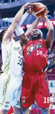  ??  ?? Bradwyn Guinto of GlobalPort foils a shot by Henton LaDontae of Alaska in the PBA Gov. Cup last night at the MOA Arena. JOEY MENDOZA