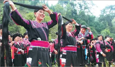  ?? WANG ZICHUANG / FOR CHINA DAILY ?? Winners of a long-hair contest show their hair to tourists in Huangluo village of Guilin, Guangxi Zhuang autonomous region, on Thursday. More than 80 women in the village have hair that is longer than 1.4 meters, with the longest being 2.72 m.