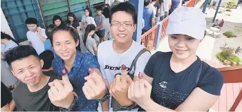  ??  ?? First time voters (from left) Alvin Keoh Kai Xian, Desmond Keoh Kai Jie, Chia Lian Jian and Chia Mei Shiah show their ink-stained fingers after casting their votes at the Sekolah Menengah Jenis Kebangsaan Cina Chung Hwa Confucian Island Park in...