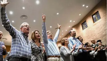  ?? — AP ?? Strength in numbers: People singing ‘ We Shall Overcome’ during a community service of hope and healing at Congregati­on Shearith Israel in Dallas.