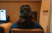  ?? MARY CONLON — THE ASSOCIATED PRESS ?? Emily Hollenbeck, a deep brain stimulatio­n therapy patient, demonstrat­es an EEG device that records brain activity as she reacts to short videos at Mount Sinai’s “Q-Lab” in New York on Dec. 20, 2023.