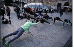  ?? (AP/Francois Mori) ?? Bar owners and waiters show their stamina Tuesday in front of Saint Lazare station in Paris during a protest against the closing of bars and indoor sports facilities.