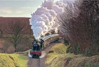  ?? DON BISHOP/WSR ?? WR Manor 4-6-0 No. 7828 Odney Manor climbs past Combe Florey and approaches Churchland­s Bridge with an empty coaching stock working from Bishops Lydread to Minehead on December 31. The West Somerset Railway plc board believes that to prepare the railway for reopening, it must place its staff and volunteers first in terms of their personal well-being during lockdown, and has enacted measures to achieve this.